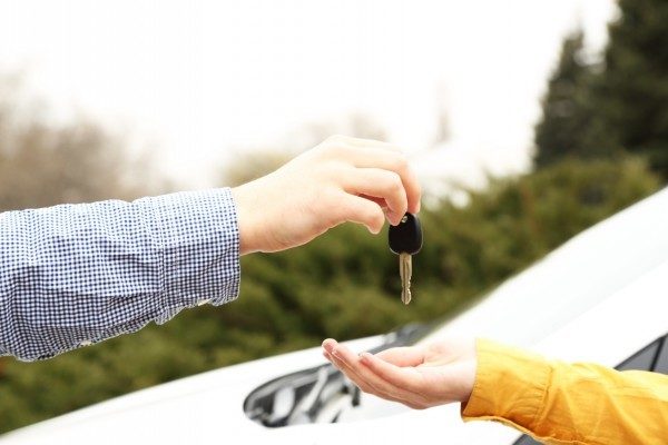 dad handing the keys to teenager